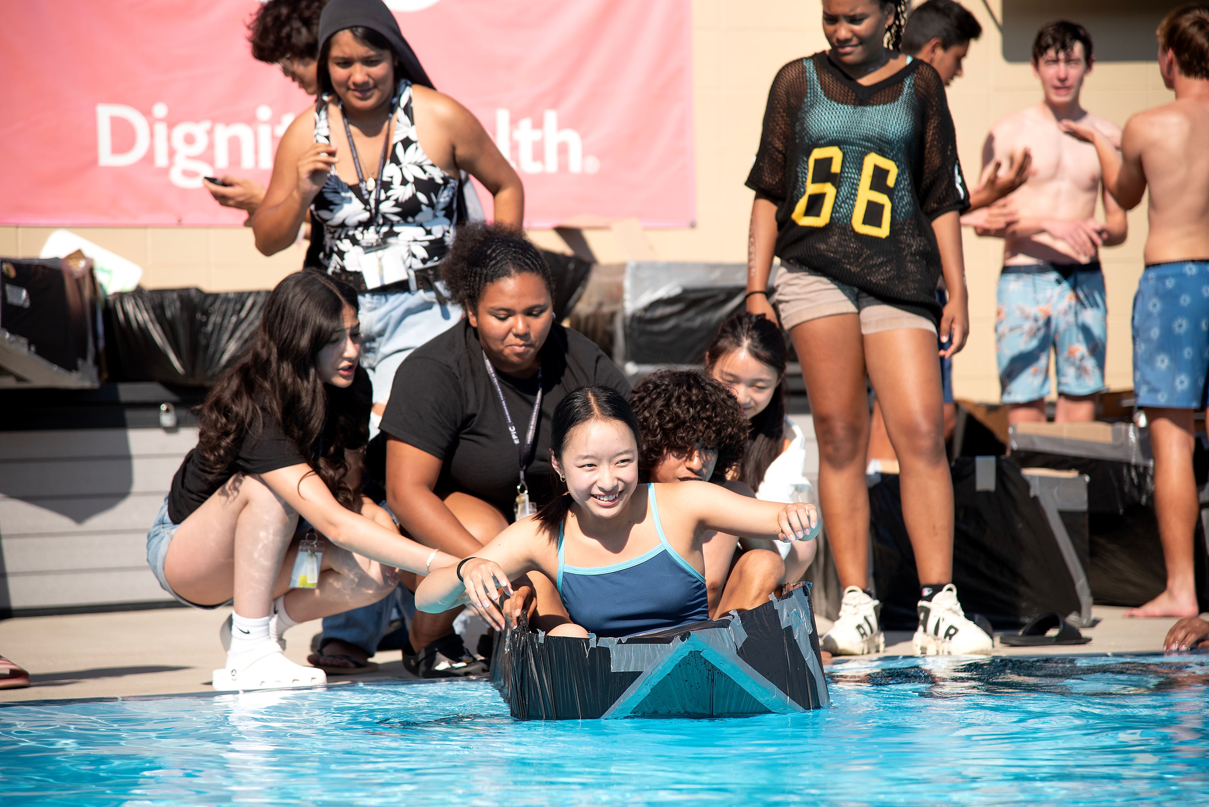 High school students participating in the summer EPIC- Engineering Possibilities in College camp launch their boat during the cardboard boat race.
